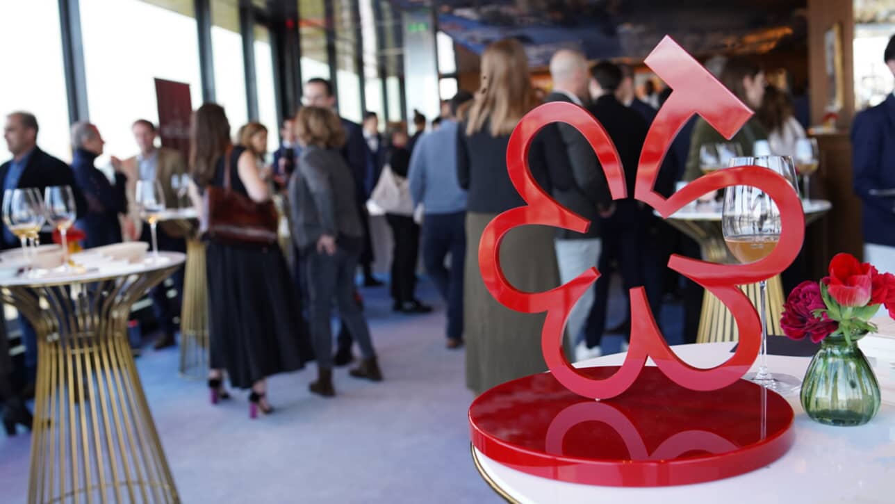Cérémonie de remise des Grappes du Guide Michelin : trophée en forme de fleur rouge devant les vignerons distingués
